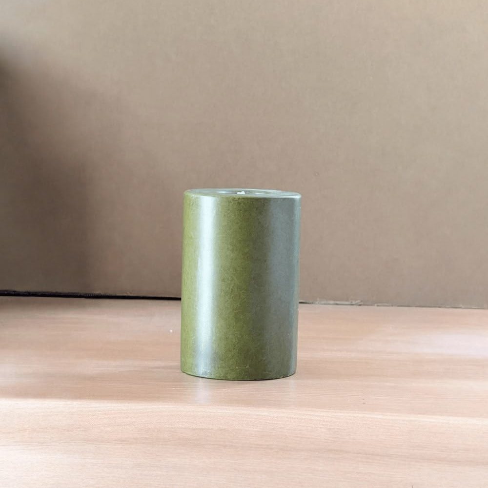 Before: green pillar candle photographed on a plain table
