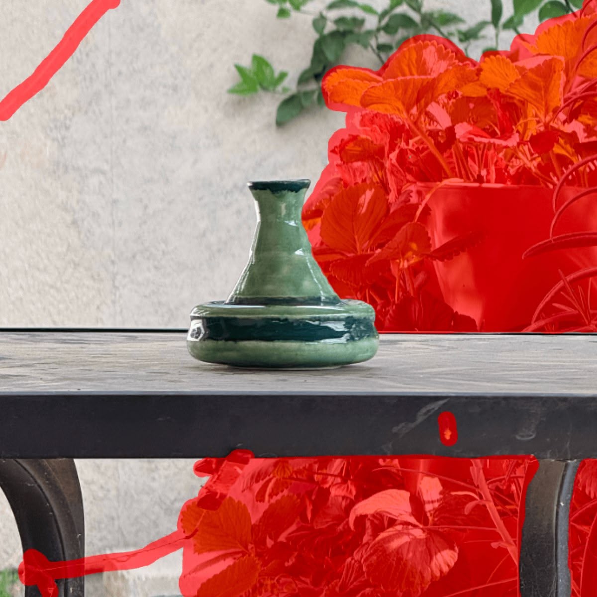 Before: green vase on an outdoor table with strawberry plants behind it